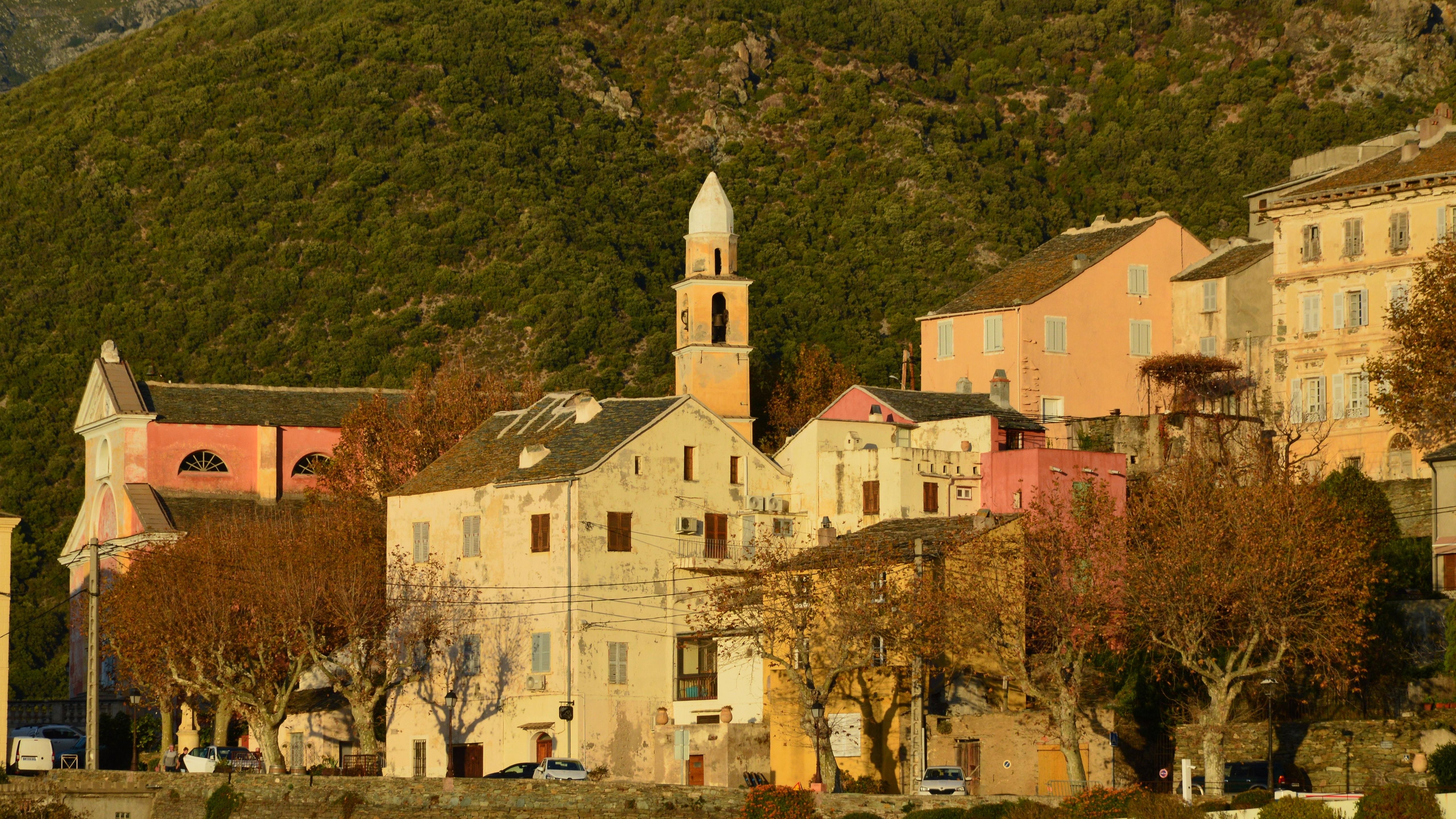 Nonza village in Corsica with traditional architecture and a lush hillside setting.