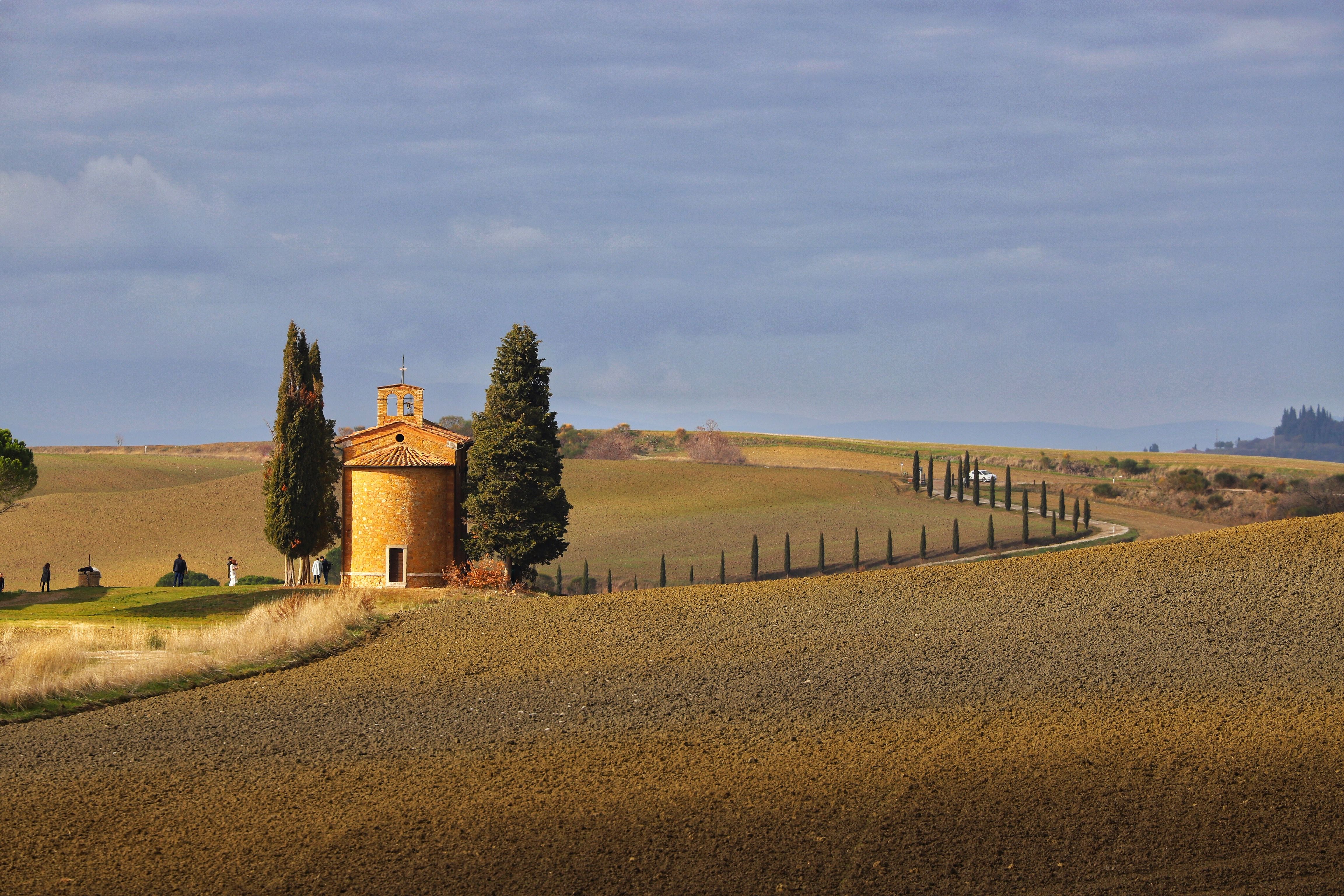 A quiet chapel amid Tuscany's rolling countryside, evoking a slower autumn getaway.